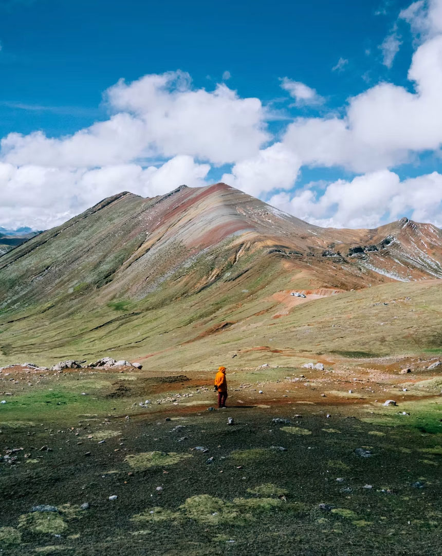 Hiker standing in front of the Palcoyo Rainbow Mountains in Peru