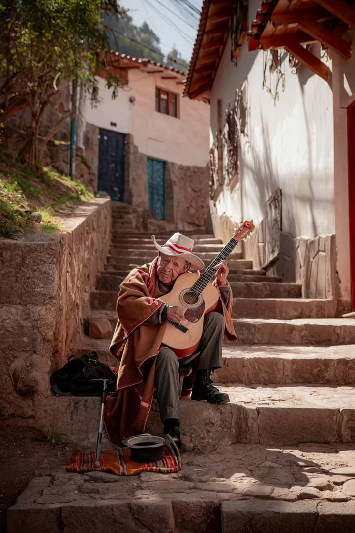 Andean musician playing guitar on a stone street in a historic village