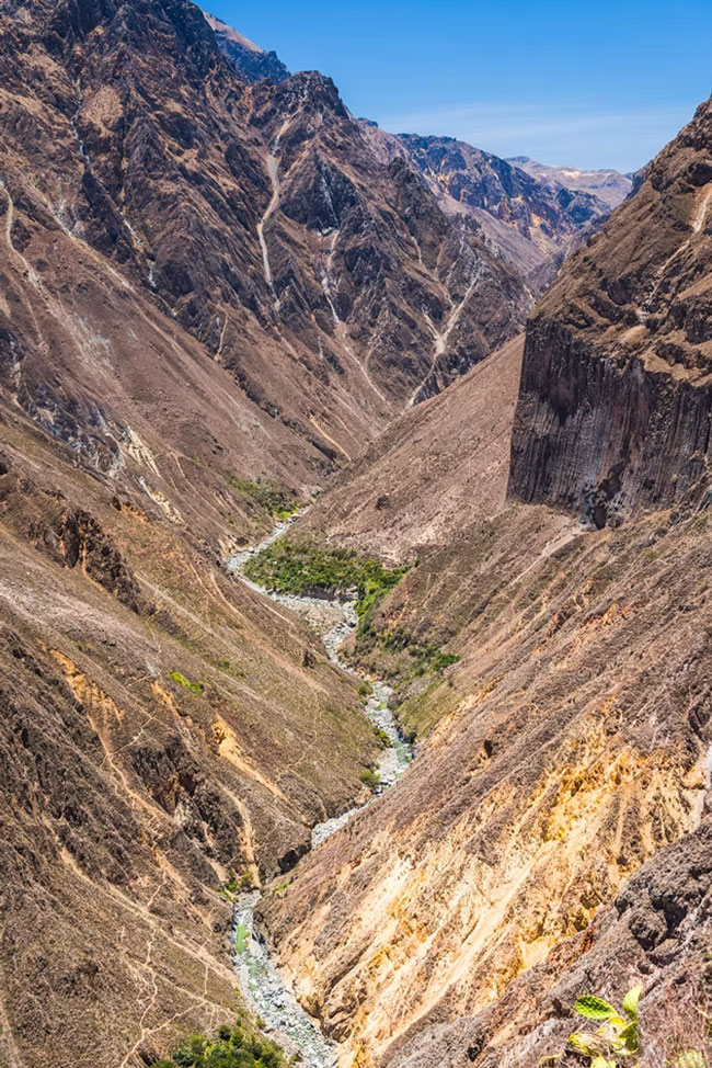 Green river running through a rocky canyon landscape in the Colca Valley