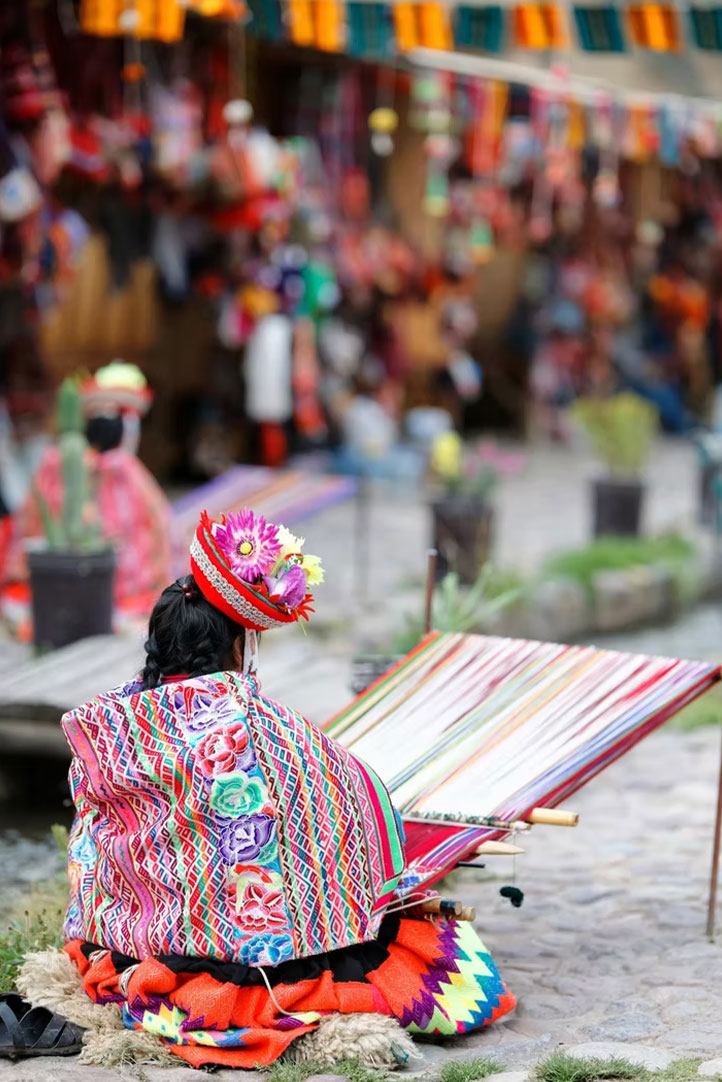 Andean woman weaving colorful textiles on a traditional loom in Peru