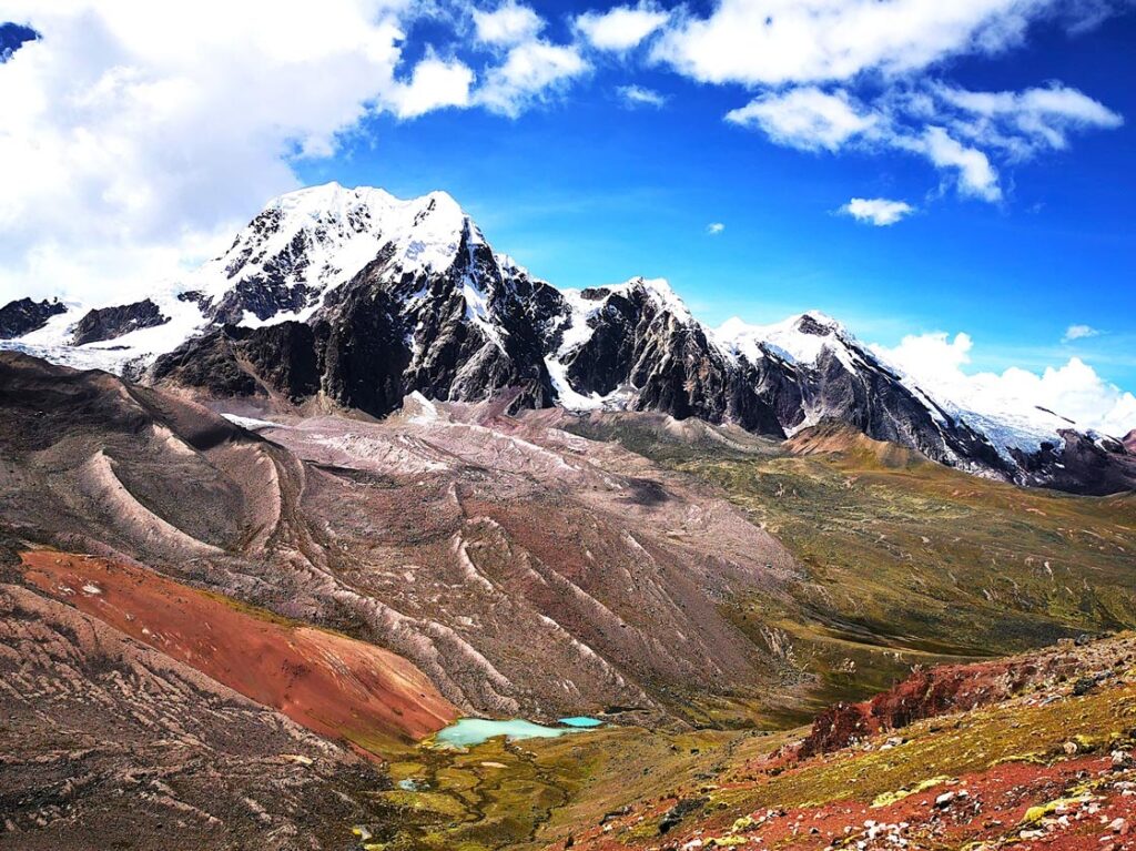 Panoramic view of Ausangate mountain with colorful valleys and turquoise lagoon in Peru